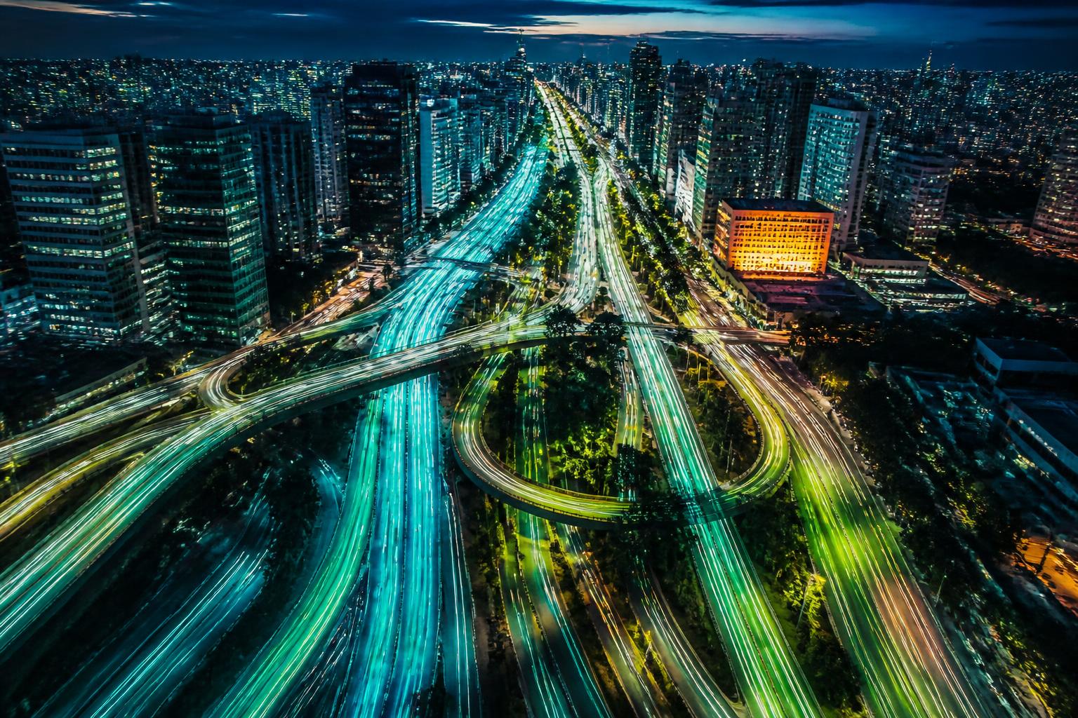 Avenidas de metrópole brasileira com rios de luz de milhões de veículos